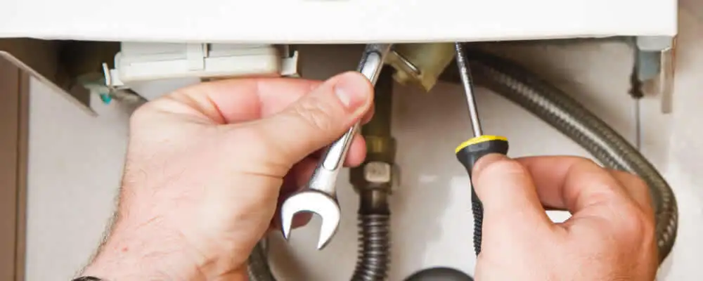 Boiler repair technician tightening pipe fittings and connections in Jacksonville, FL