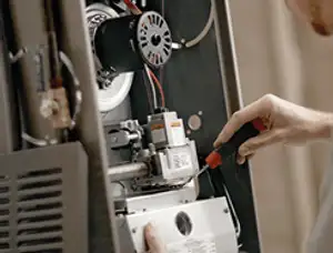 Furnace repair technician inspecting internal components and wiring in Jacksonville, FL