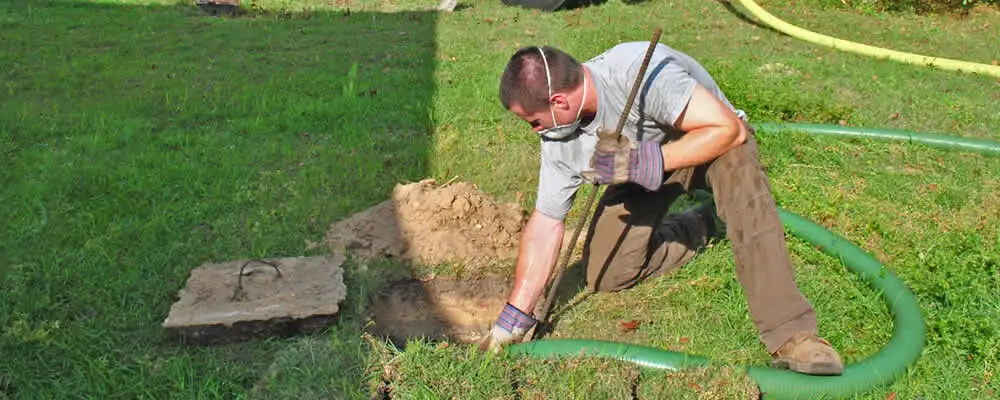 Septic pumping technician servicing a residential septic tank in Jacksonville, FL