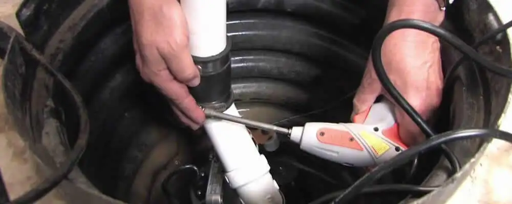 Sump pump installation technician connecting PVC discharge piping in Jacksonville, FL
