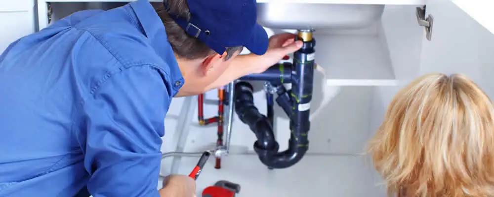 Plumber repairing under-sink drain pipes and fittings in Jacksonville, FL