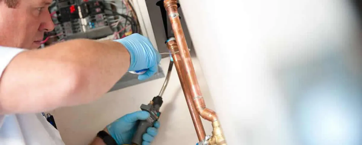 Water heater repair technician testing copper pipe connections and controls in Jacksonville, FL